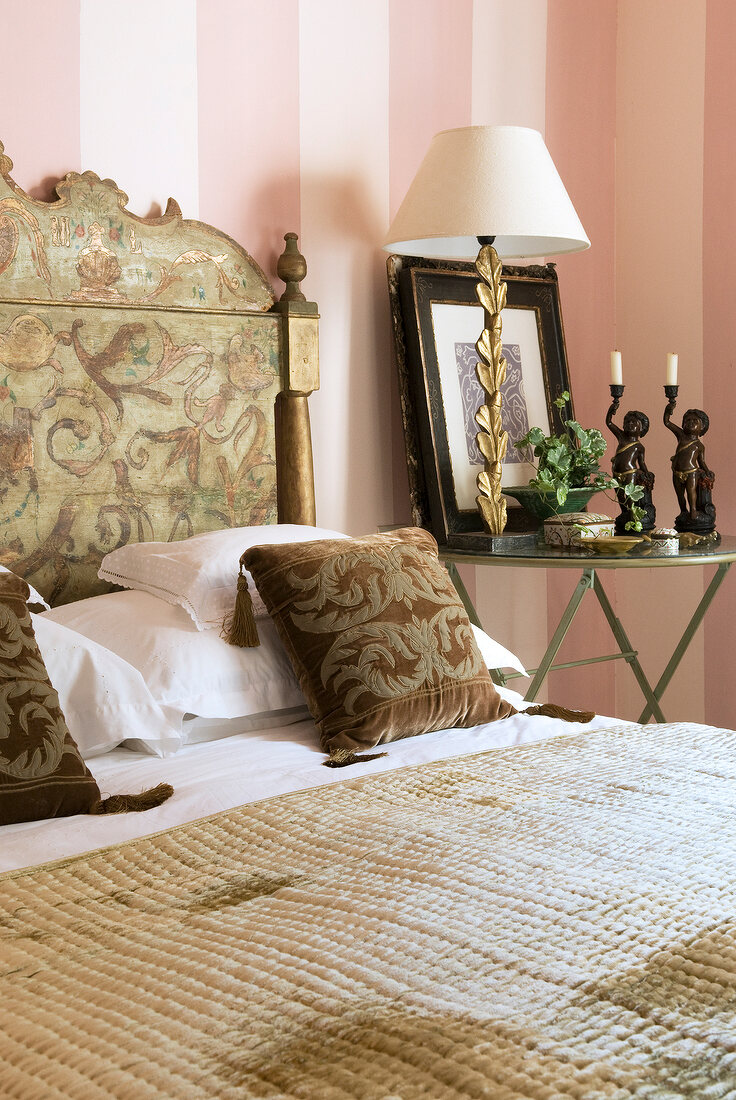 Spanish styled bedhead and cushions on bed in bedroom