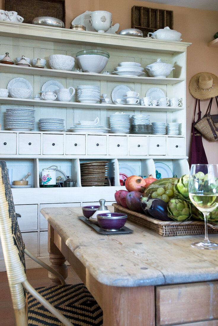 Porcelain crockery on white shelf in kitchen