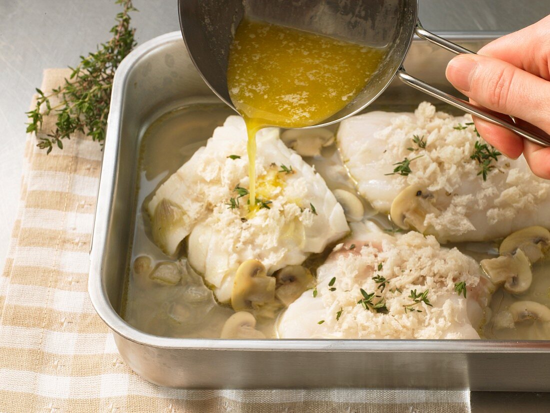 Fish fillet being drizzled with butter