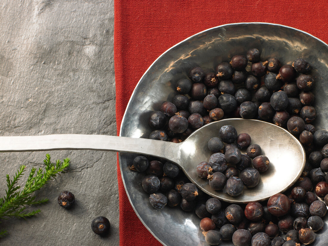 Juniper berries on spoon and plate