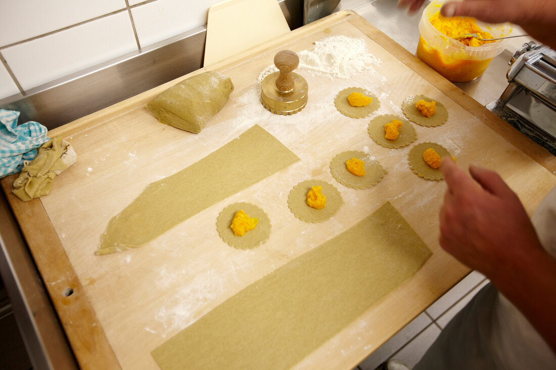 Filling dough circles while preparing pumpkin bags