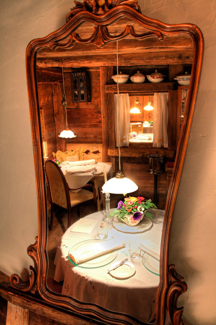 Reflection in mirror of set table at Restaurant La Stua de Michil, South Tyrol, Italy