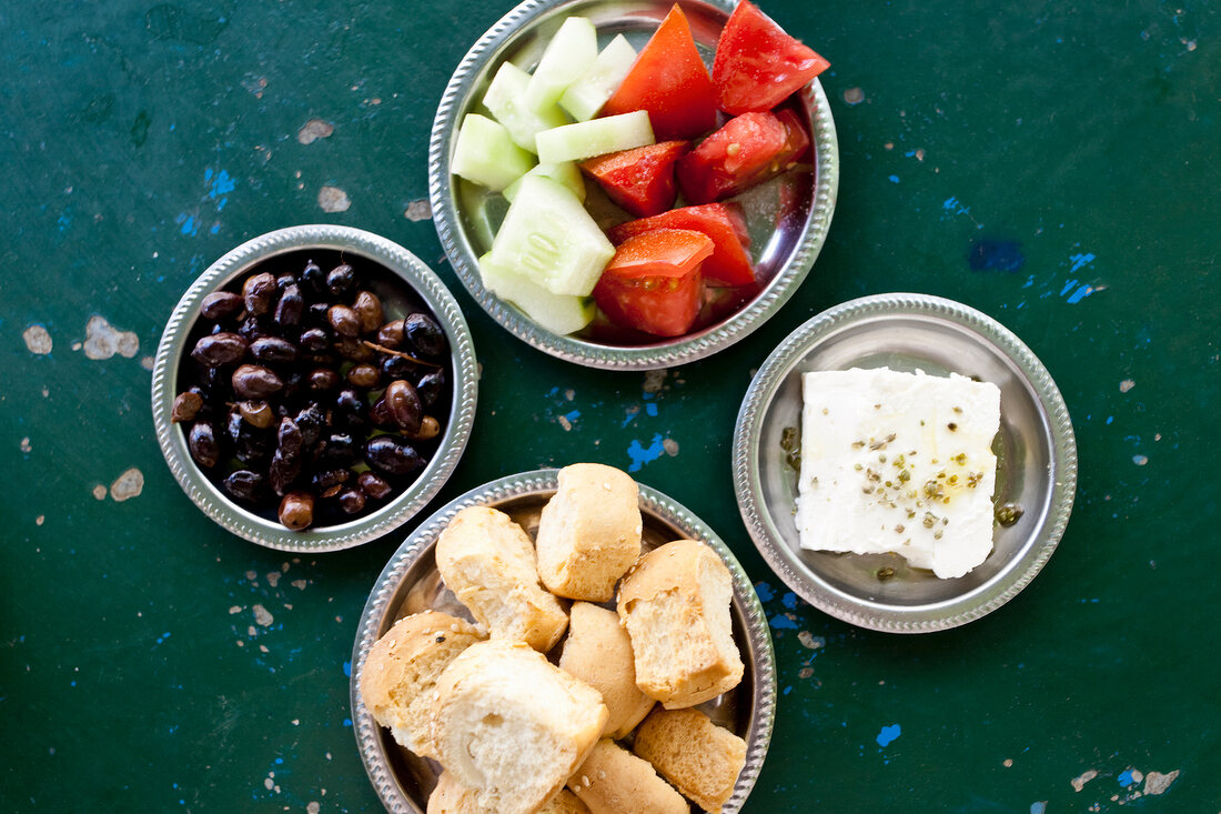 Olives, bread, feta, tomatoes and cucumber on plates