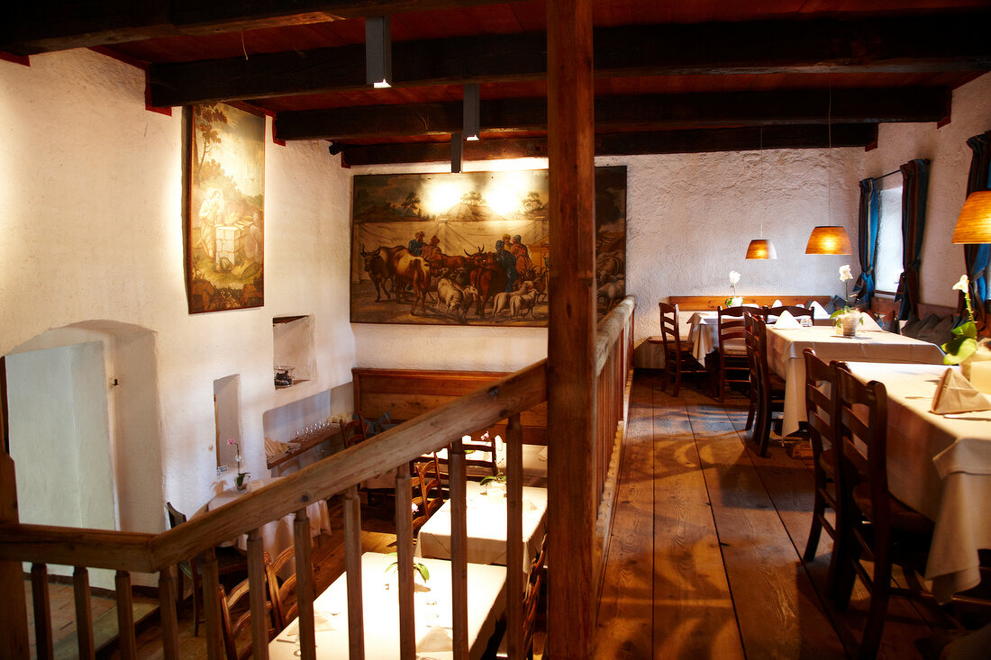 Illuminated wooden dining room in restaurant at Tscherms