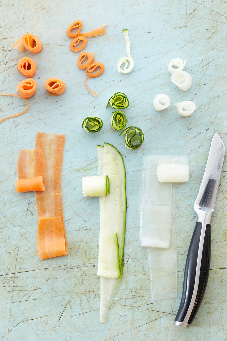 Strips of radish, cucumber and carrots rolled up, overhead view