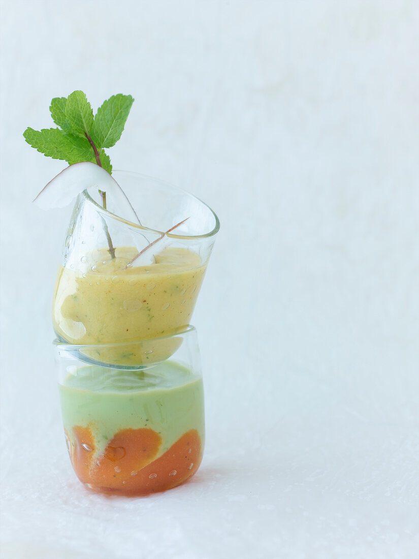 Curried mango smoothie and avocado papaya smoothie in small glasses