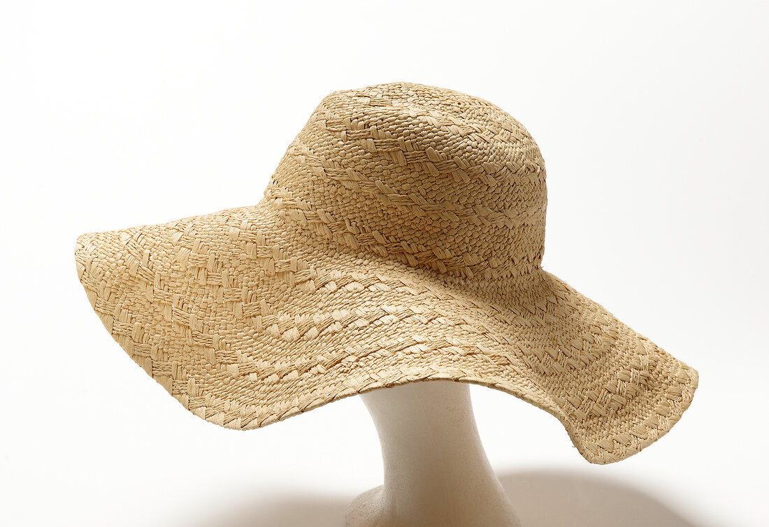 Close-up of raffia hat on white background