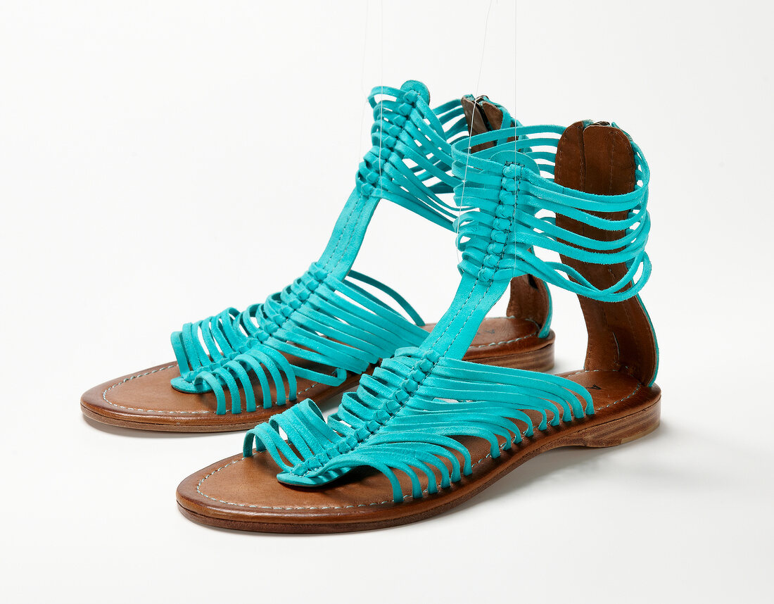 Pair of blue roman sandals on white background