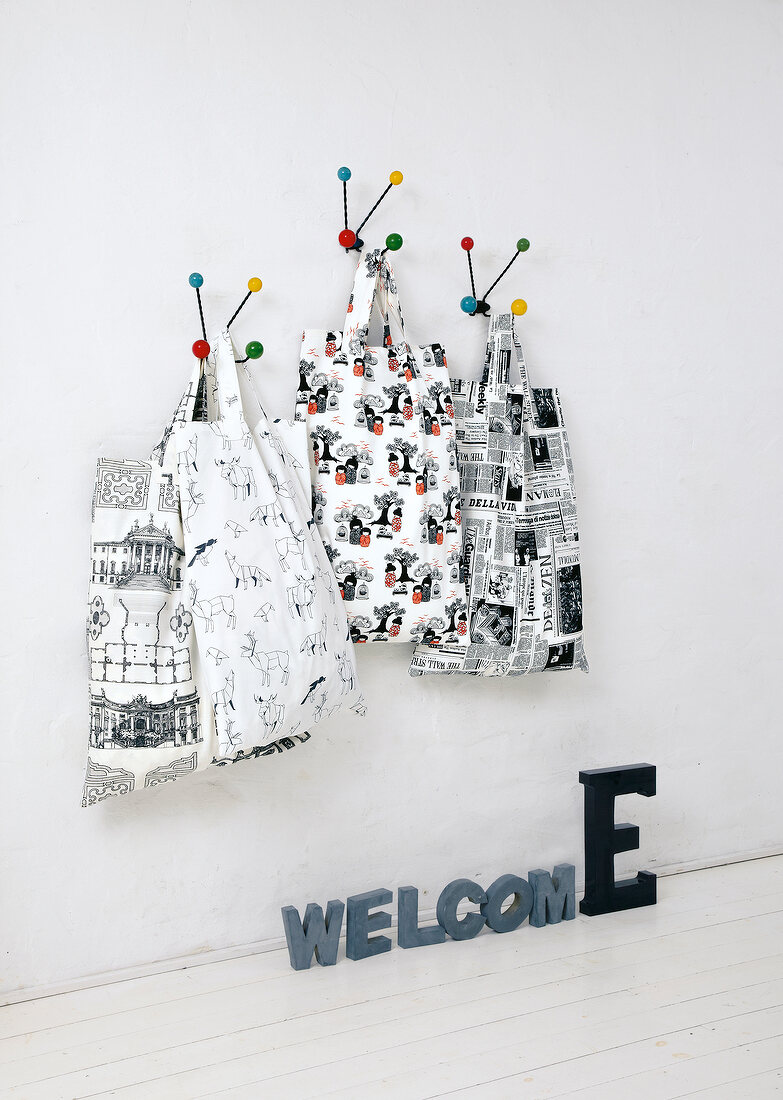 Four black and white bags hanging on multi-coloured hooks with text blocks