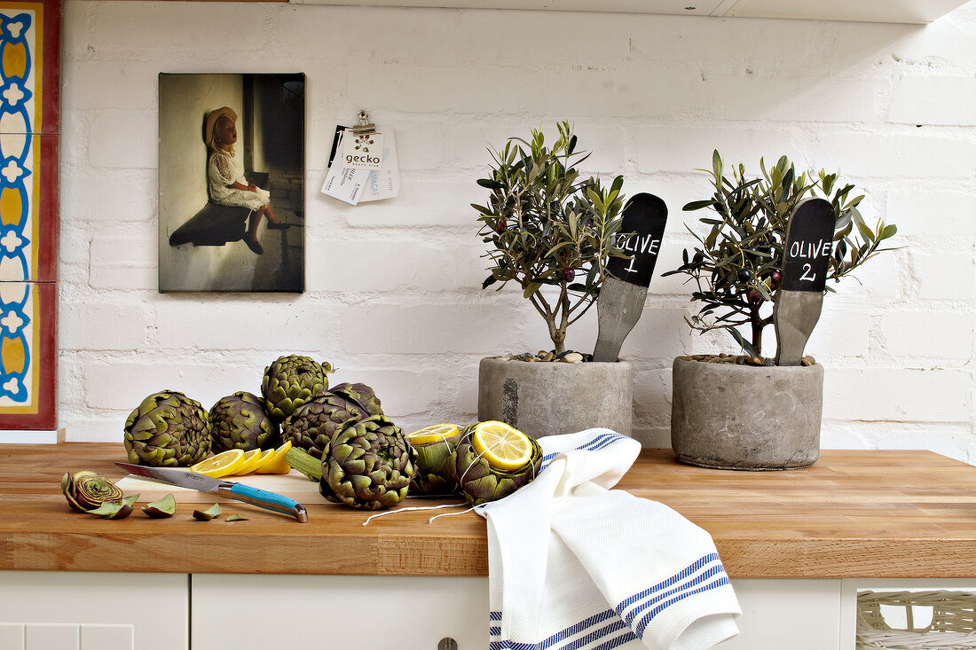 Olive trees, artichokes and lemon slices on table