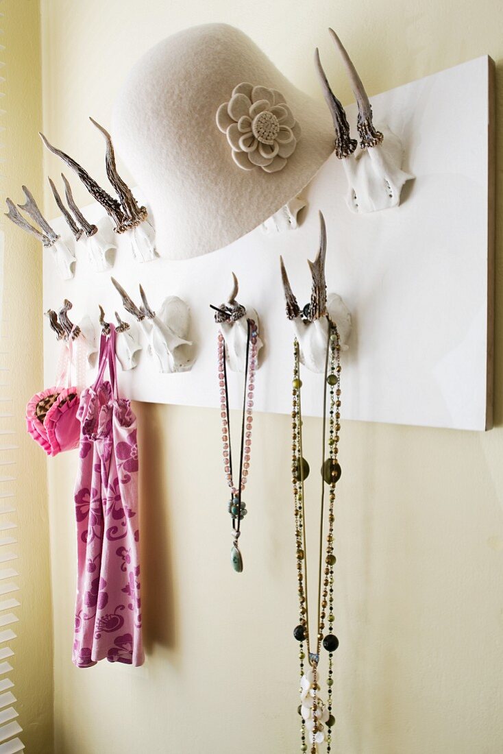 Coat rack with antler hooks; hat, necklaces and jewellery hanging on hooks