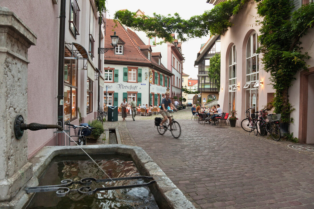 People on street and Freiburg houses in Black Forest, Germany