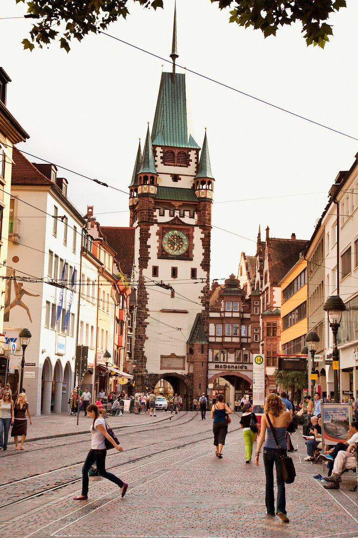 People walking on street of old Martinstor in Freiburg, Black Forest, Germany