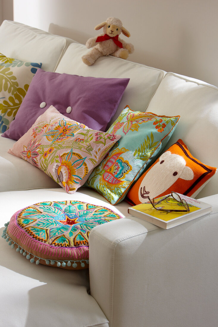 Bunte Kissen auf weißem Sofa – Bild kaufen – 10240258 ❘ Image Professionals