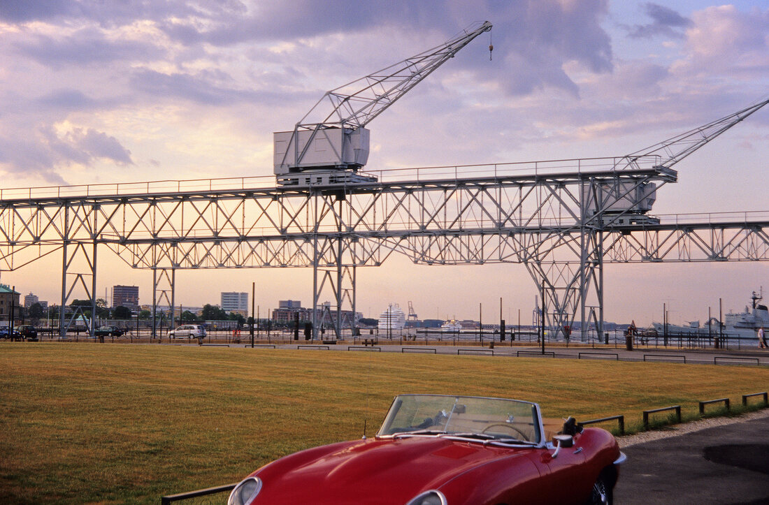 View of Red Jaguar E-type in front of port crane at Holmen, Copenhagen, Denmark