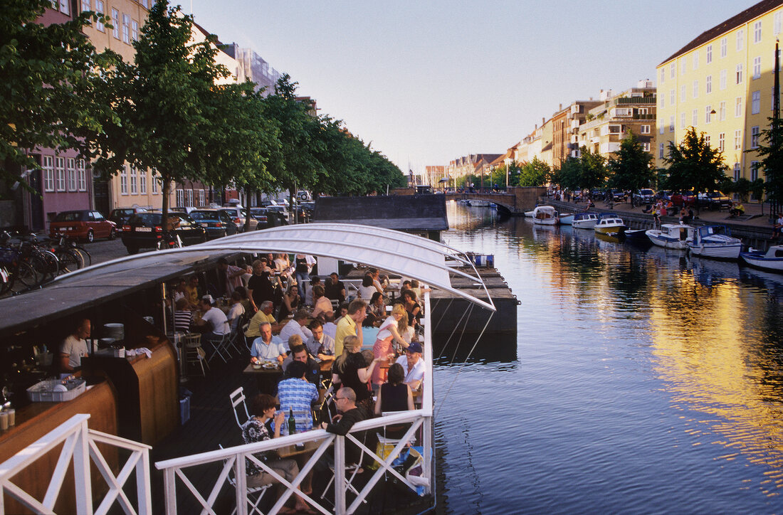 People sitting at table on Christianshavns Kanal, Copenhagen, Denmark