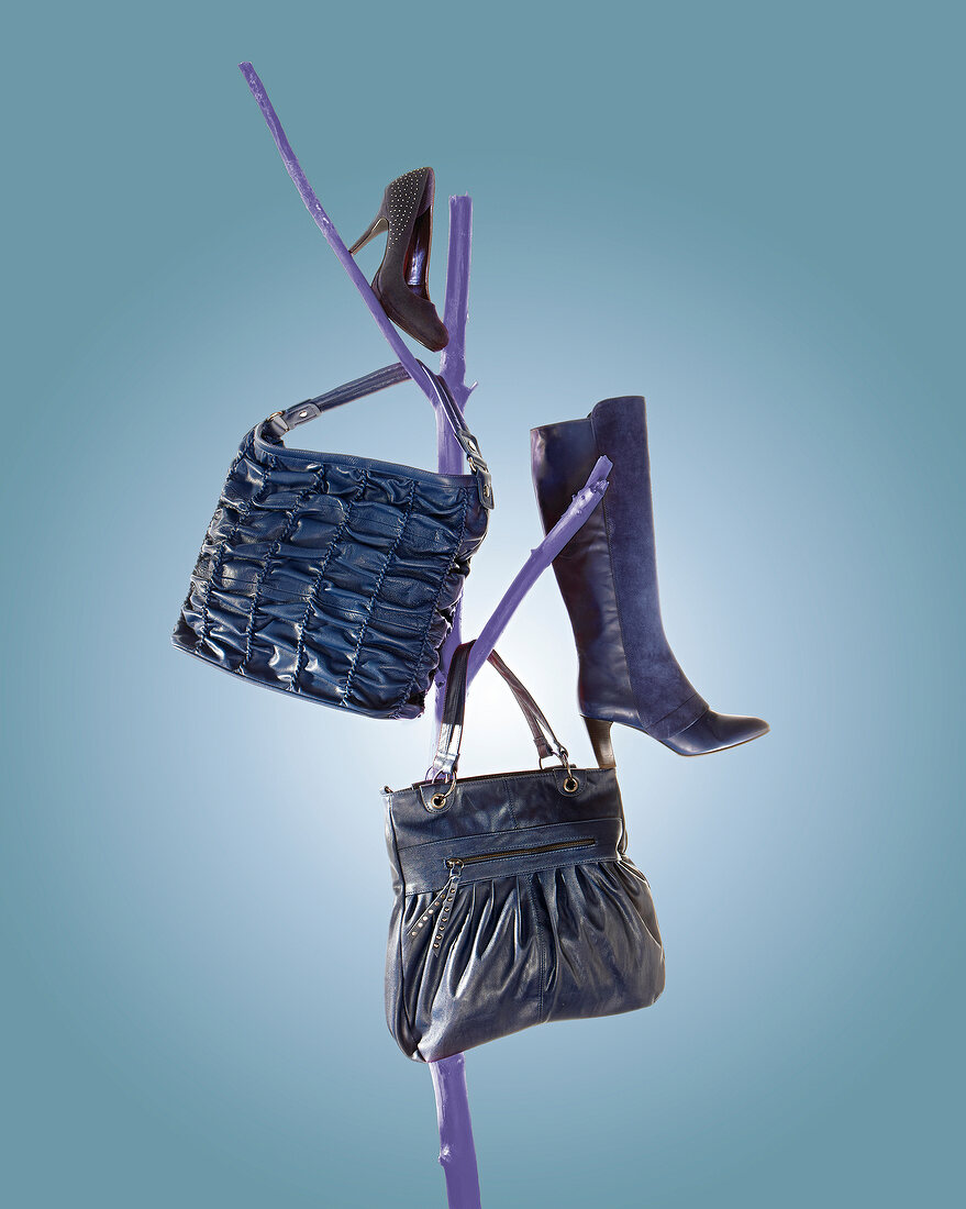Taschen und Schuhe  im Jeanslook hängen an blauen Zweigen