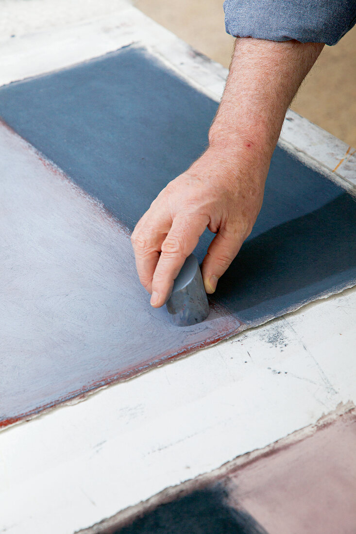 Close-up of artist Sean Scully applying chalk on layer