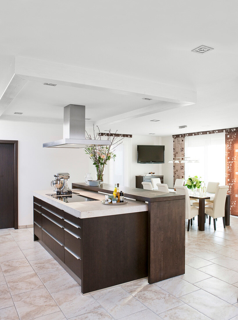 Interior of dining area of kitchen, bridge counter with hob and extractor