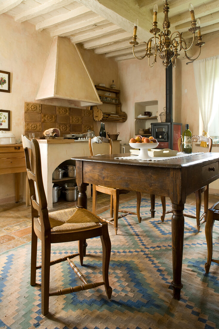 Old oak table with chair and candlestick chandelier in Palazzo, Italy