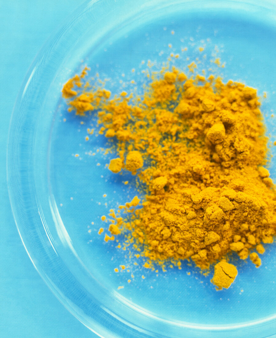 Close-up of turmeric powder on glass plate