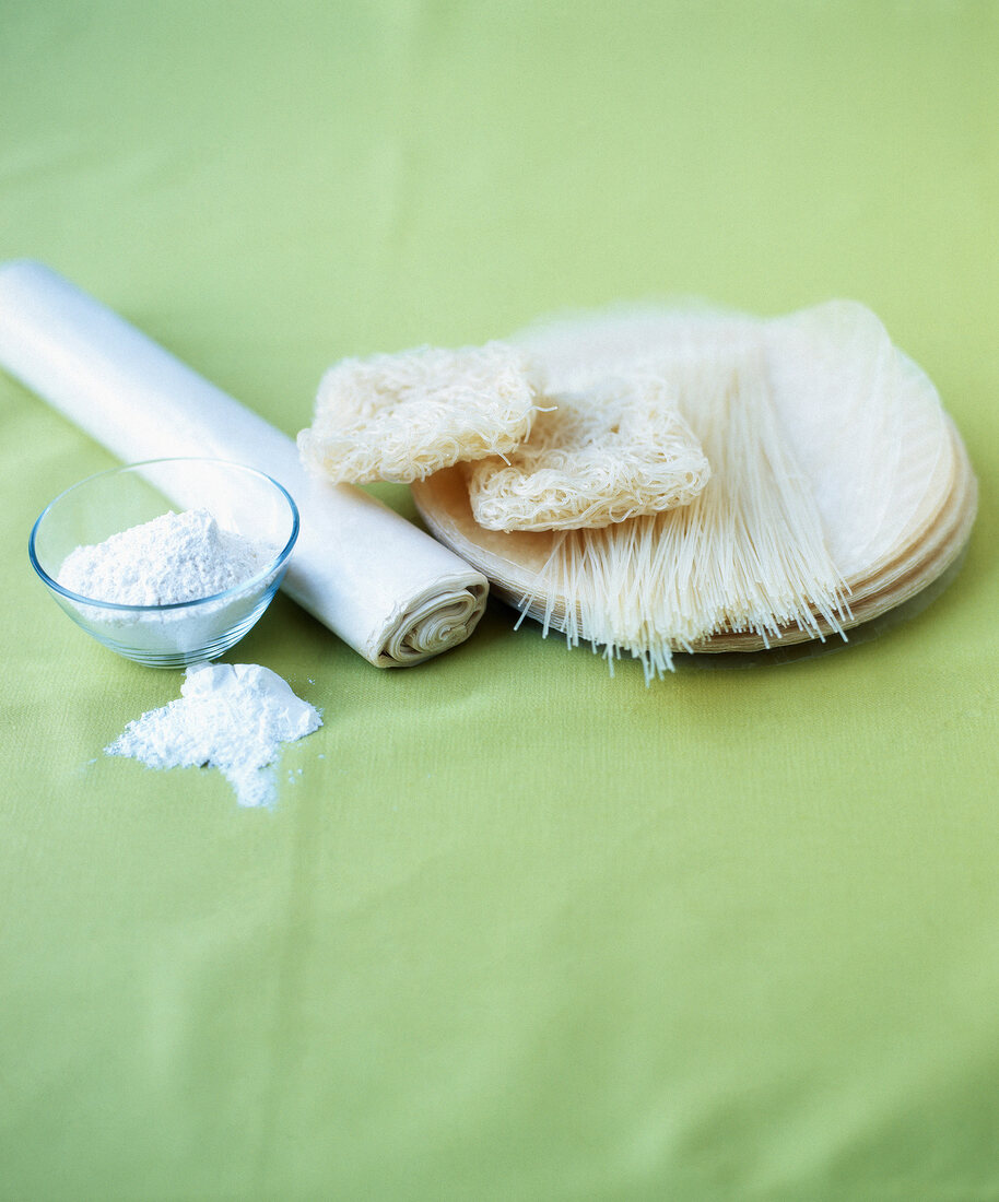 Filo pastry, rice noodles, rice leaves, tempura and tapioca flour on green background