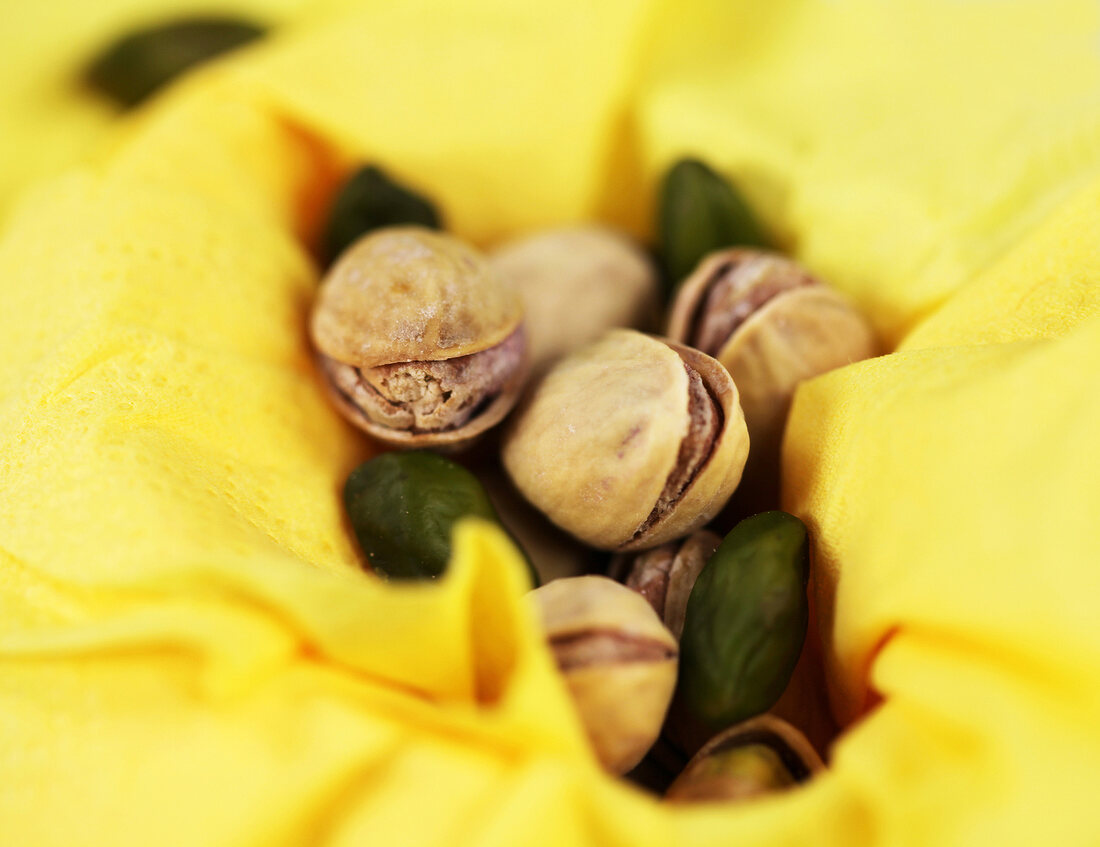 Pistachio in broken shell on green background