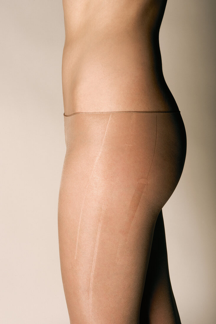 Side view of woman's buttocks and thighs wearing transparent mask for sensitive skin