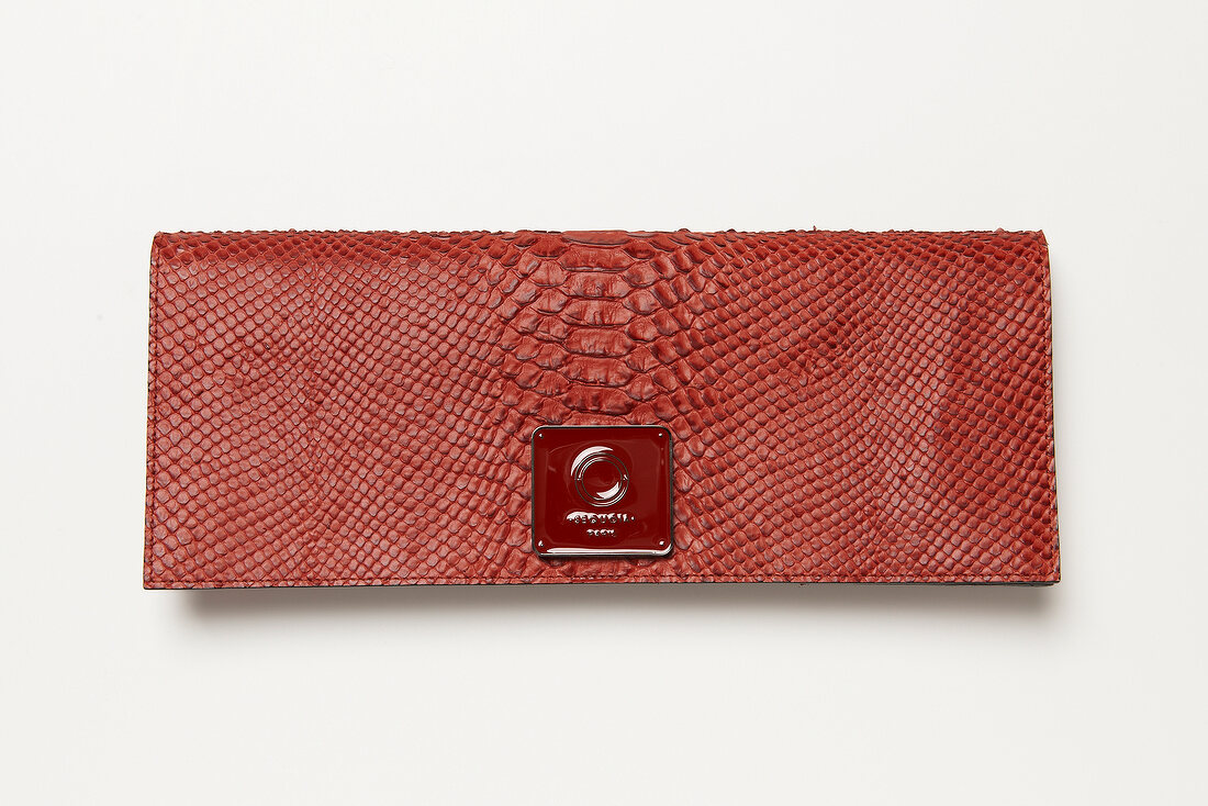 Red calf leather clutch with reptile embossing on white background