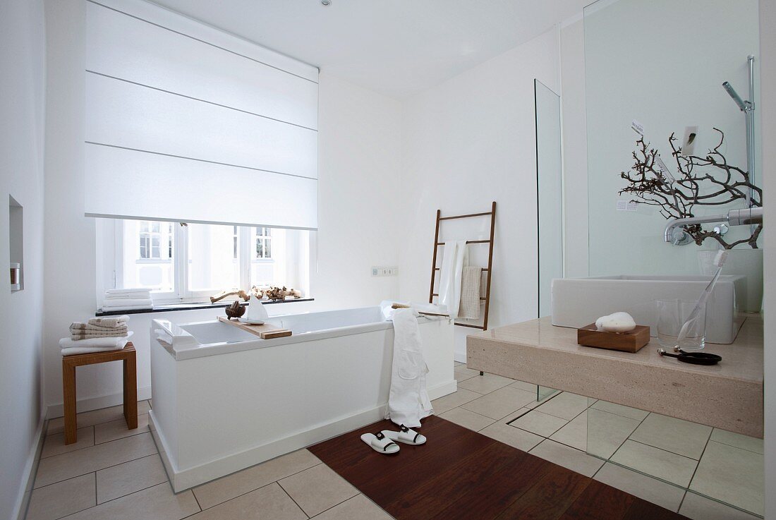 A spacious bathroom in white with touches of brown
