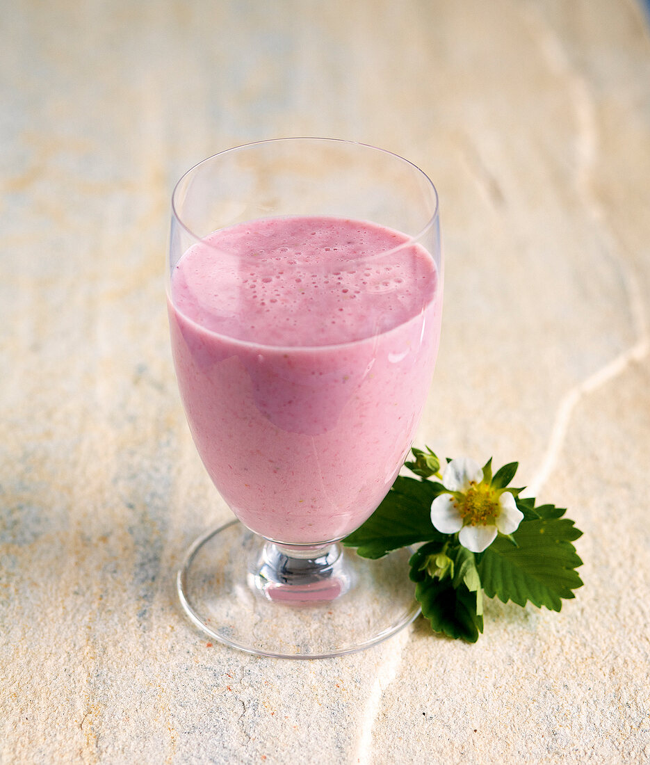 Flower next to glass of juice