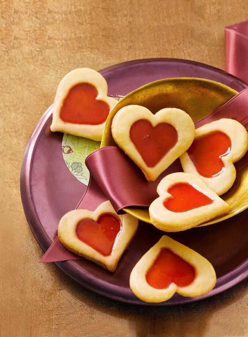 Close-up of heart shaped cookies with raspberry jelly filling on plate