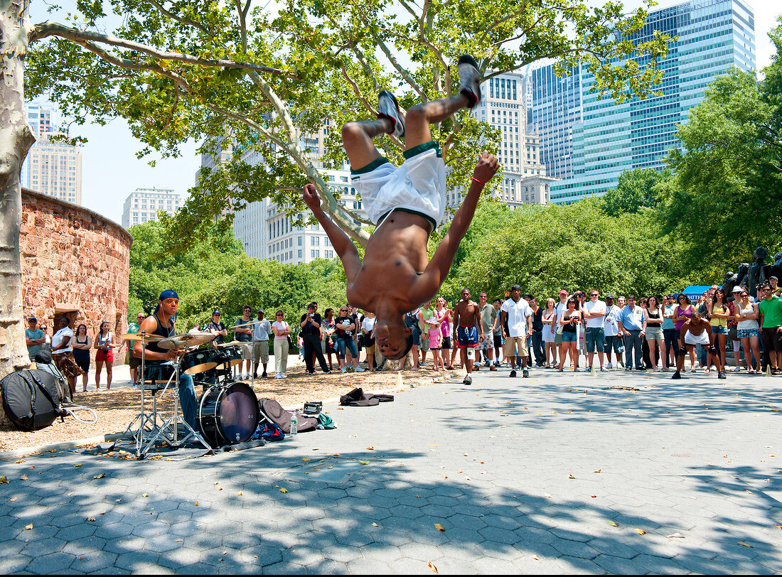 Crowd watching street musicians and dancers perform at Battery Park, New York, USA