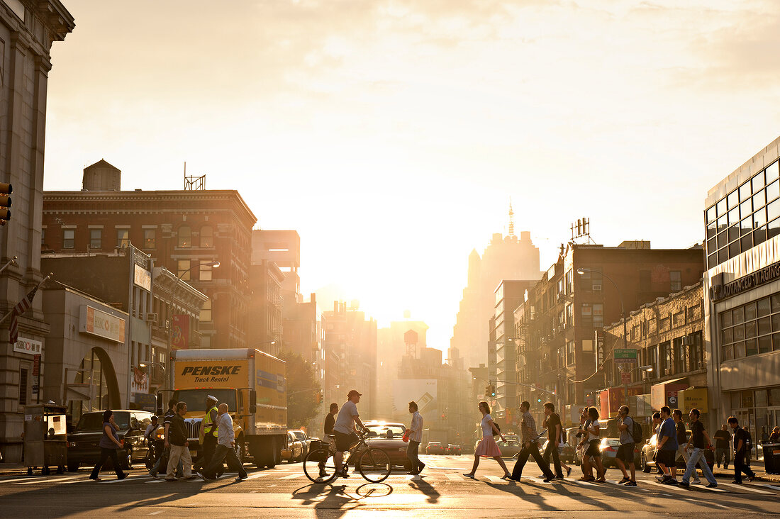 People crossing road at Chinatown street during sunset, New York, USA