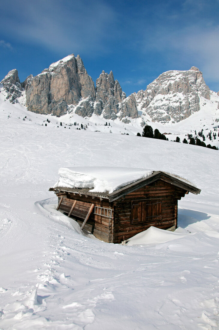 Mountain hut with snow at Gardena pass in front of Sella Group, Italy