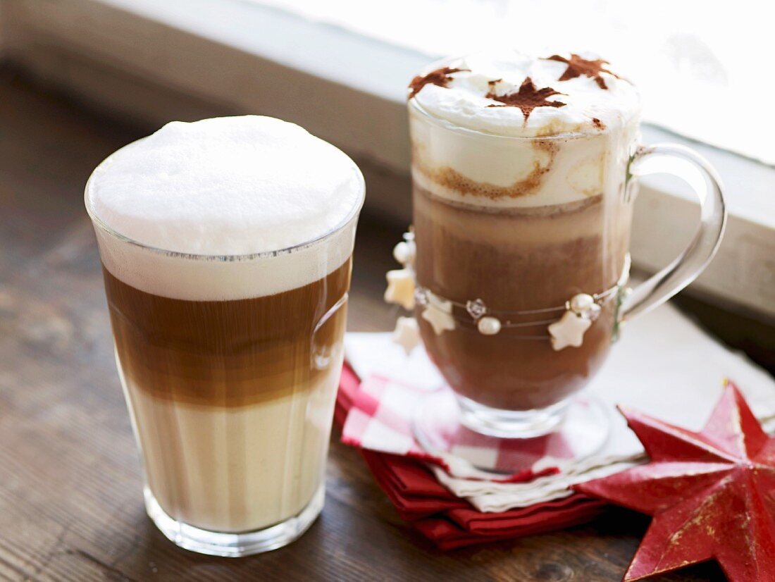 A latte macchiato and a chocolate coffee decorated with cocoa stars