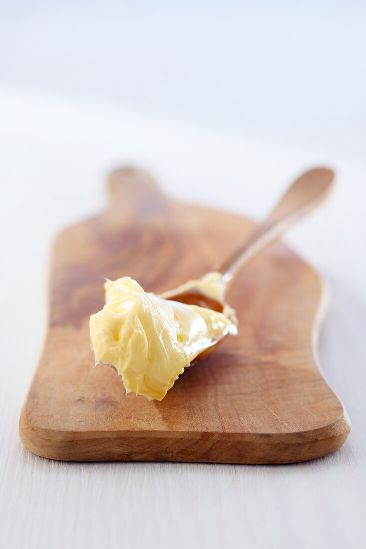 Close-up of spoon with butter on cutting board