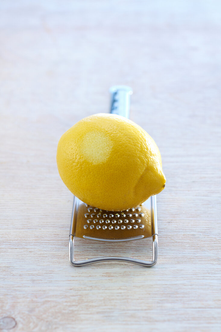 Zitrone liegt auf einer Reibe 