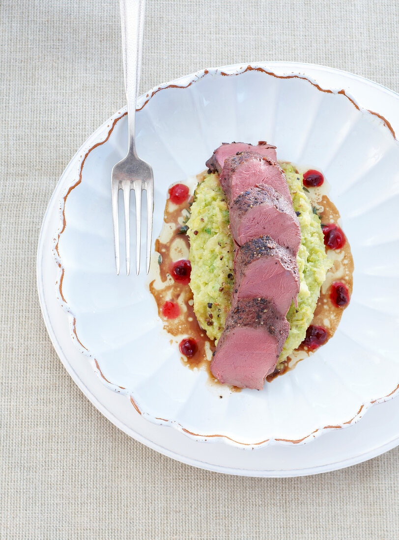 Hare with Brussels sprouts and cranberry puree in serving dish, overhead view