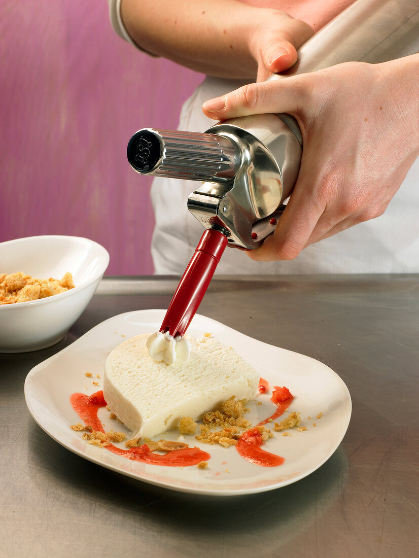 Dollop of cream being placed on parfait, step 3