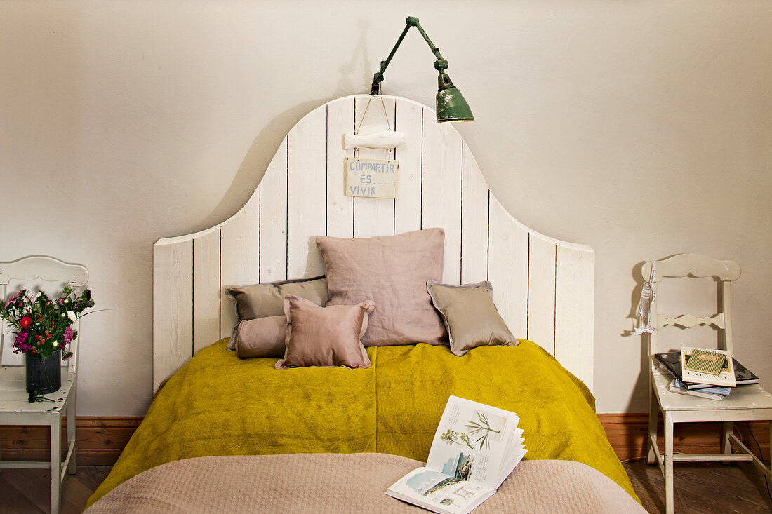 Modern bed with country style headboard, cushions and lamp