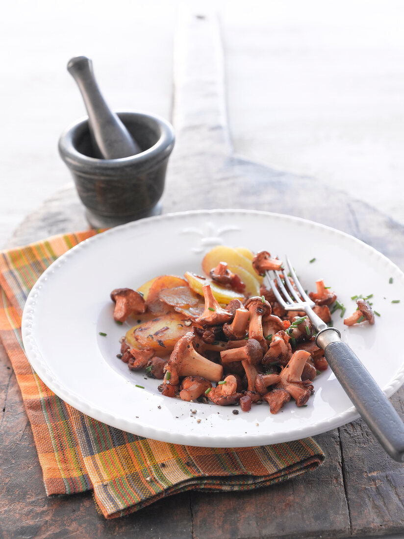 Chanterelles with fried potatoes on plate