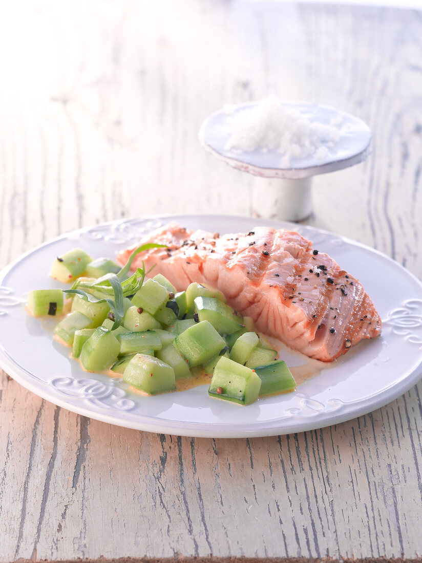 Grilled salmon with cucumbers on plate