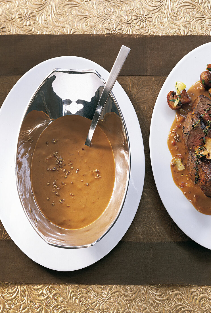 Close-up of venison with pepper sauce in serving dish