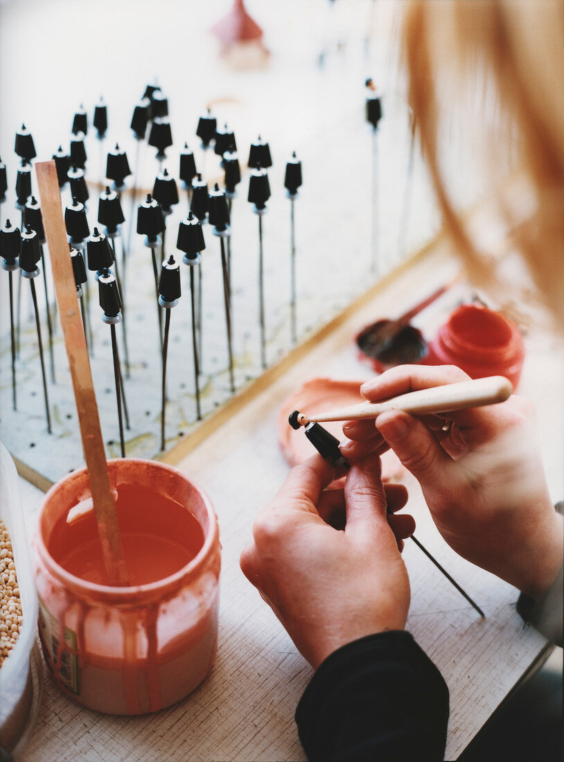 Close-up of woman painting wooden figures