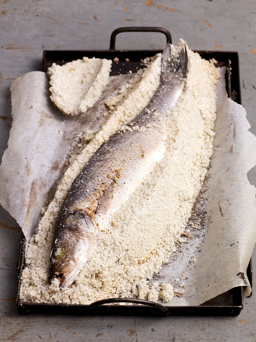 Close-up of sea bass in salt crust on baking tray