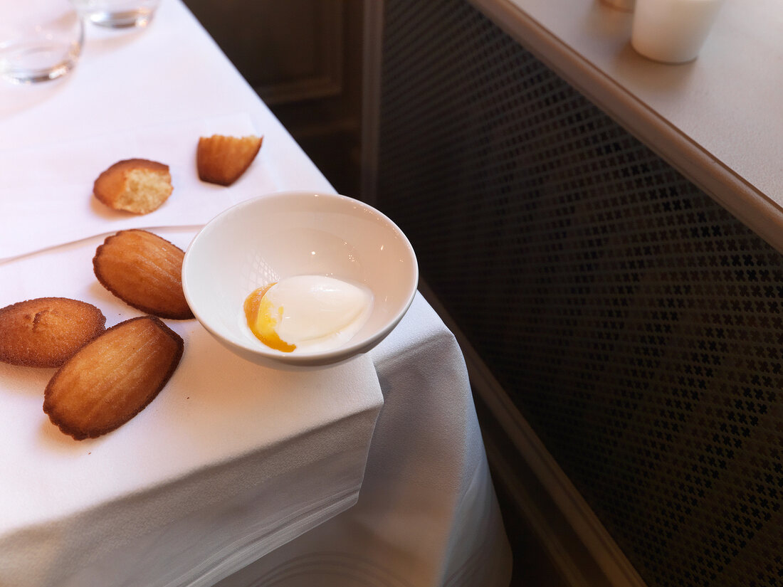 Warm honey madeleins with quark ice cream on table