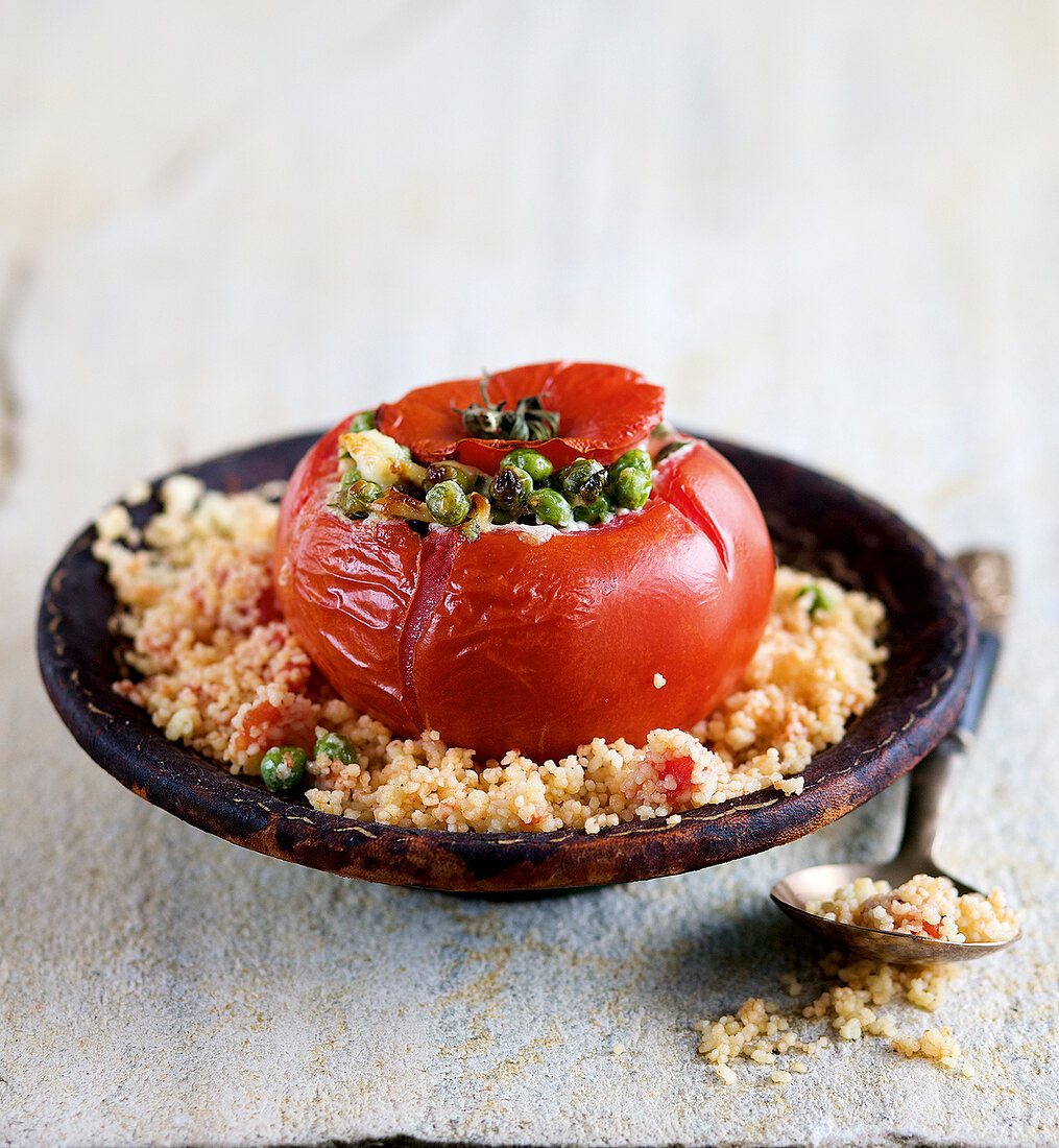 Close-up of stuffed tomatoes on couscous in bowl