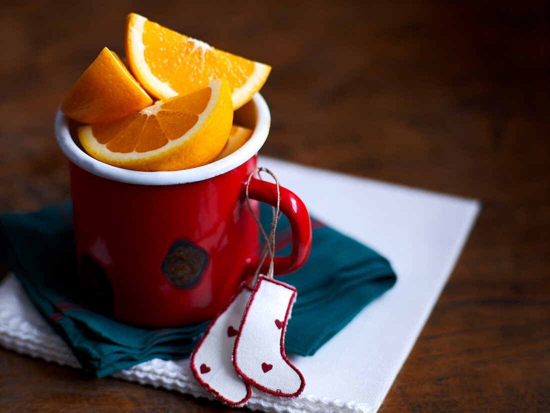 Weihnachten, roter Becher voller Orangenviertel