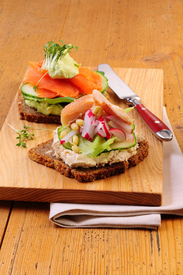 Whole wheat bread with toppings on wooden board